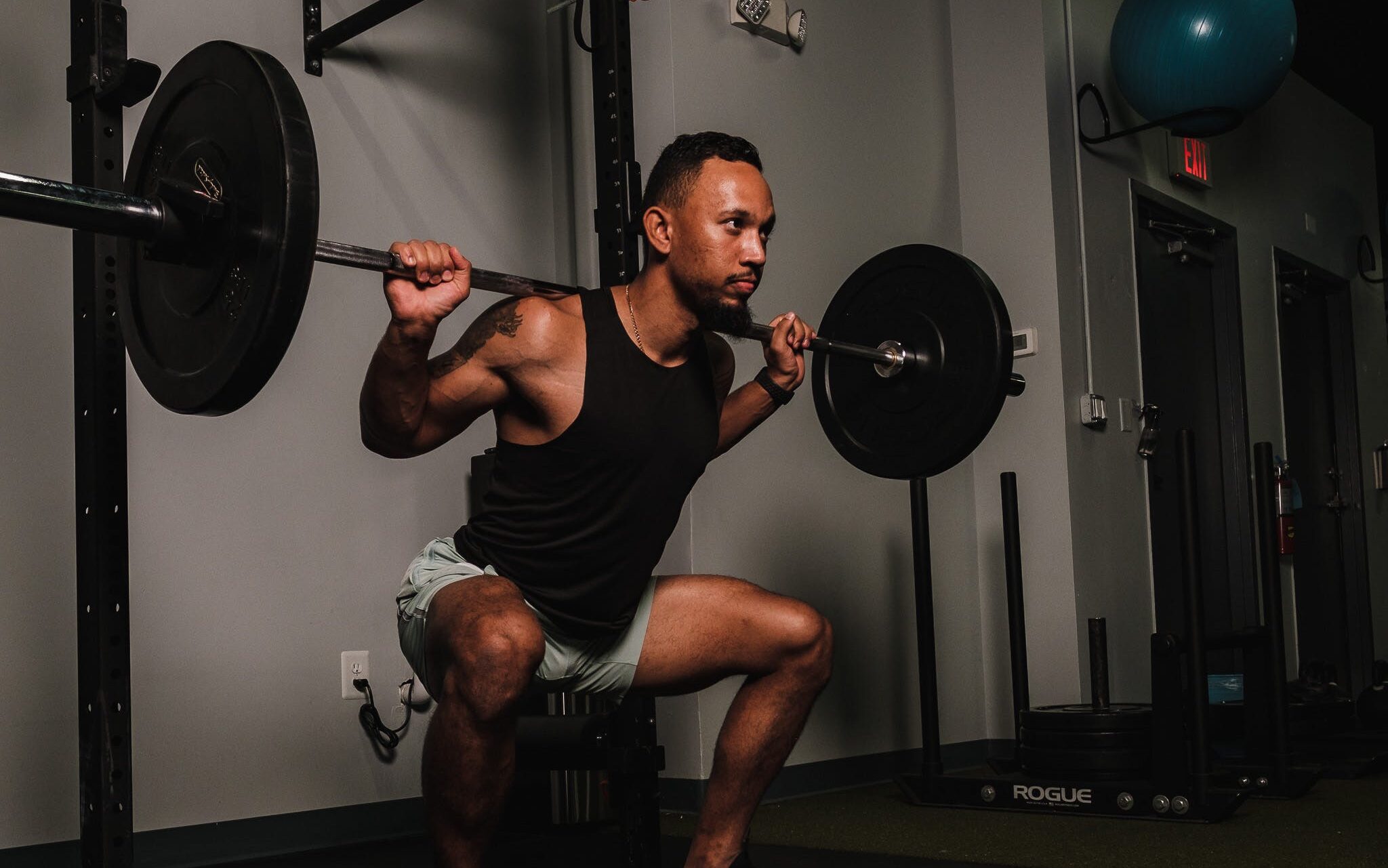 Man does light squat on squat rack